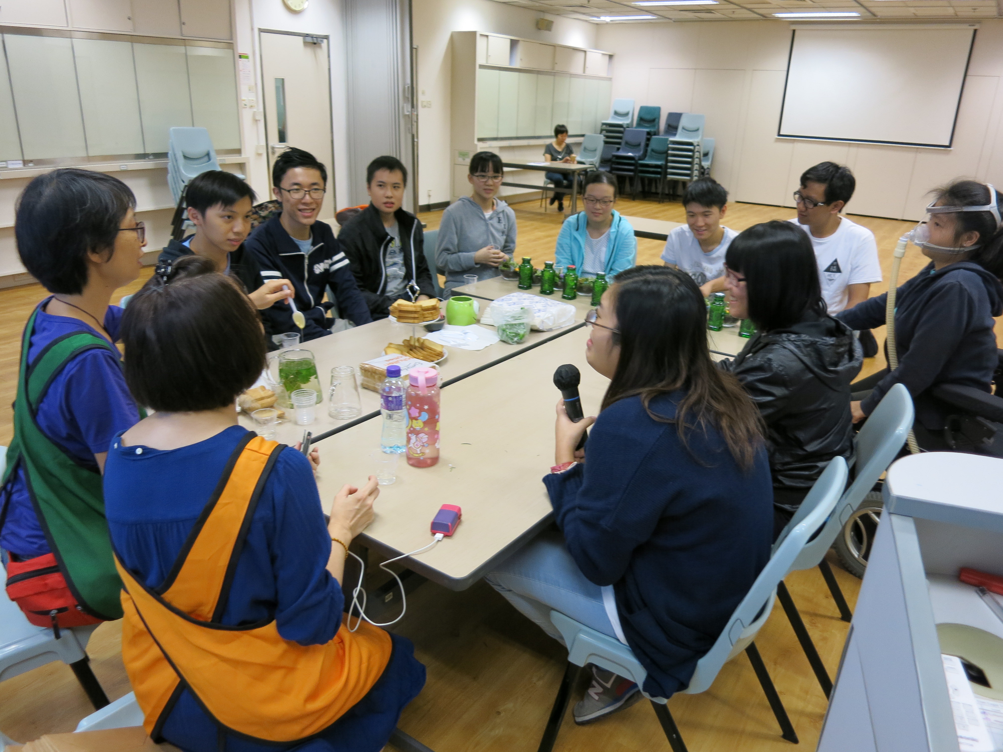 Students were sitting surrounding the long table where they could interact with the teachers and follow the instructions given by them to undertake the therapy. 
